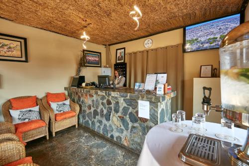 a woman sitting at a counter in a restaurant at Big Valley Game Lodge in Lobatse