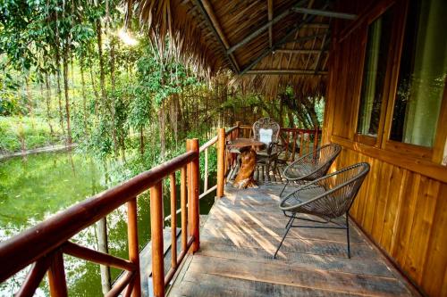 a porch of a cabin with chairs and a table at Hang Lan Bungalow in Ninh Binh