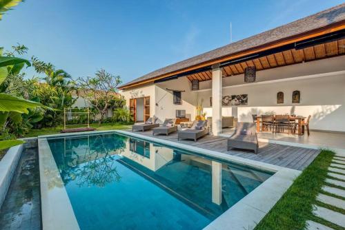 een villa met een zwembad voor een huis bij Echo Beach Villa and Apartment in Canggu