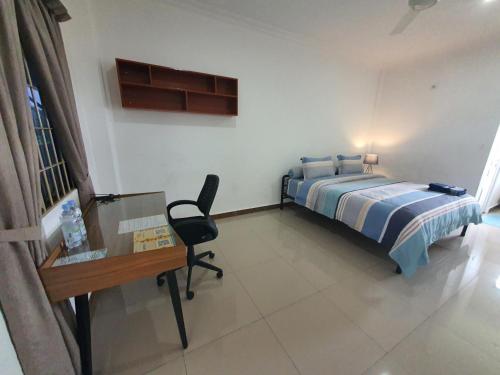 a bedroom with a bed and a desk and a glass table at MB Apartments & Hotel Medan in Sunggal