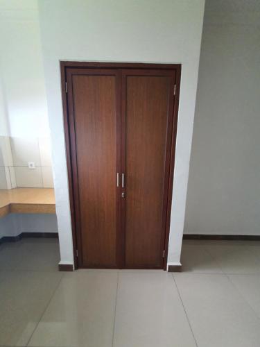 a pair of wooden doors in a room at MB Apartments & Hotel Medan in Sunggal