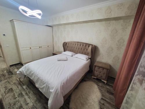 a bedroom with a large bed with white sheets at Luxury Apartament Bacovia in Bacău