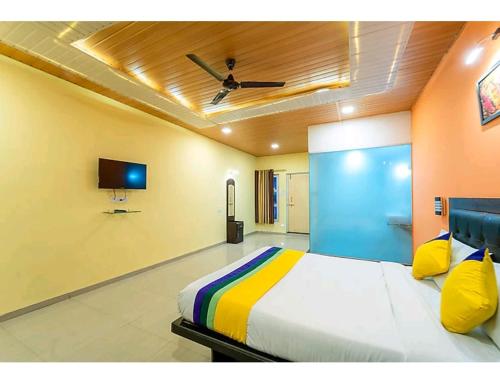 1 dormitorio con 1 cama y TV de pantalla plana en New Sun n S Resort Matheran, en Matheran