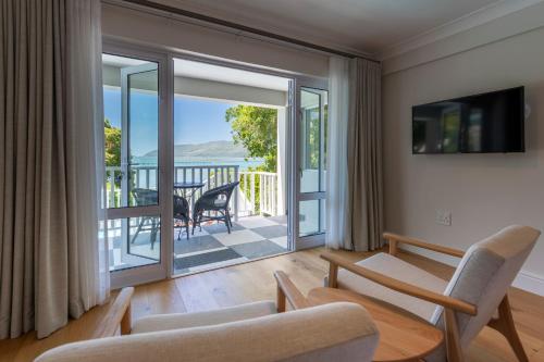 a living room with a view of a balcony at Hide-Away Guest House in Knysna