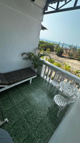 a balcony with a bench and a table and chairs at Hawaii Lounge in Sihanoukville