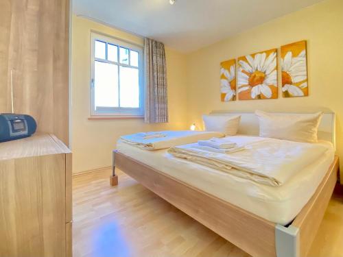 - une chambre avec un grand lit blanc et une fenêtre dans l'établissement Neue Villa Ernst - Ferienwohnung 4, à Bansin