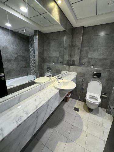 a bathroom with two sinks and a toilet and a tub at Shared Private Room in Downtown Business Bay in Dubai