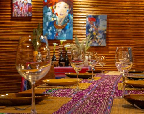 a table with wine glasses and plates on it at Sapaxa Spring Garden Ecolodge in Sa Pa