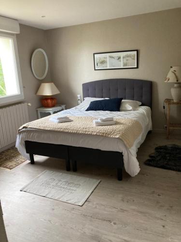 um quarto com uma cama grande com duas toalhas em Maison Blanche em Coudeville
