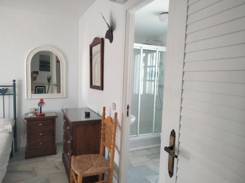 ein Schlafzimmer mit einer Kommode und einem Schreibtisch mit einem Spiegel in der Unterkunft Apartamento primera línea de playa in Manilva