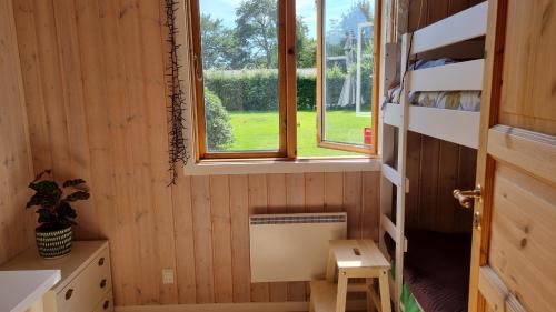 a tiny house with a window in a room at Charming summer house close to the sea in Dronningmølle