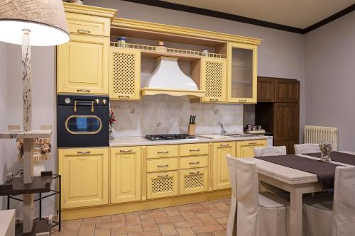 a kitchen with yellow cabinets and a dining table at Casa Vèra Affittacamere Appartamenti in Orvieto