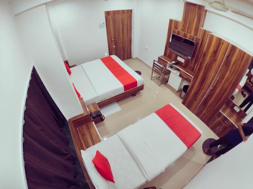 uma vista panorâmica de um quarto com 2 camas e uma televisão em Hotel Nawanagar Residency em Jamnagar