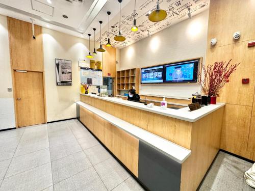 a lobby of a restaurant with a woman sitting at a counter at Shanghai Ange Hotel - Next to Longyang Road Subway Station, Near New Internatonal Expo Center in Shanghai