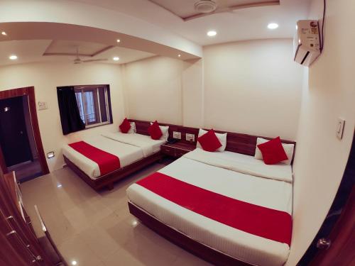 a room with two beds with red pillows at Hotel Nawanagar Residency in Jamnagar