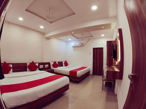 a hotel room with two beds and a tv at Hotel Nawanagar Residency in Jamnagar