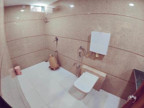 a small bathroom with a toilet and a shower at Hotel Nawanagar Residency in Jamnagar