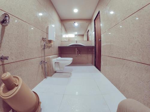 a bathroom with a toilet and a sink at Hotel Nawanagar Residency in Jamnagar