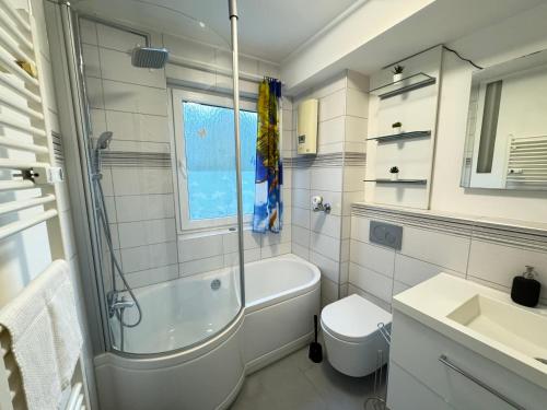 a bathroom with a tub and a toilet and a sink at A05 - Wohnung für 6 Pers - 3 Zi mit Balkon inkl smart TV in Bad Homburg vor der Höhe