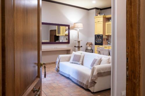 a living room with a white couch and a mirror at Casa Vèra Affittacamere Appartamenti in Orvieto