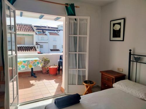 Schlafzimmer mit einer Tür, die auf eine Terrasse führt in der Unterkunft Apartamento primera línea de playa in Manilva