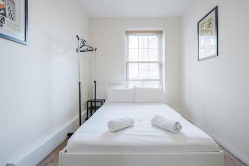 a white bedroom with a bed with two towels on it at APlaceToStay Central London Apartment, Zone 1 OX in London