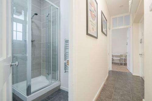 a bathroom with a shower with a glass door at APlaceToStay Central London Apartment, Zone 1 OX in London