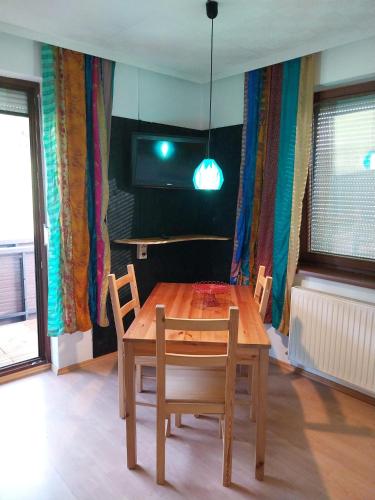 a dining room with a wooden table and chairs at Kriegwald Apartements in Julbach