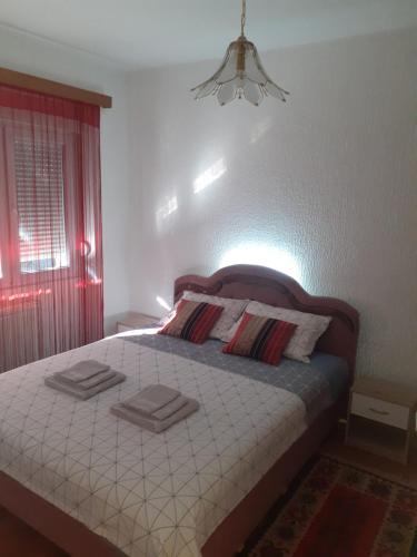 a bedroom with a bed with two towels on it at Zanovetak in Sombor