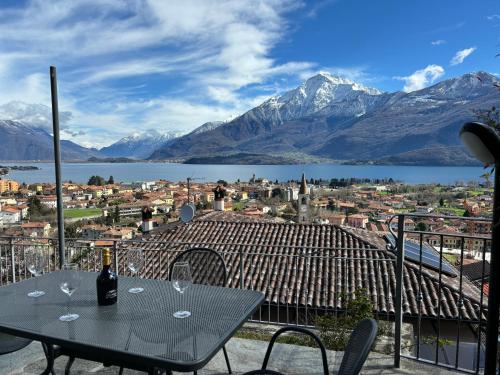 una mesa con copas de vino en un balcón con montañas en Lake view, Garden, Balcony in Gravedona - Larihome A61 en Consiglio di Rumo