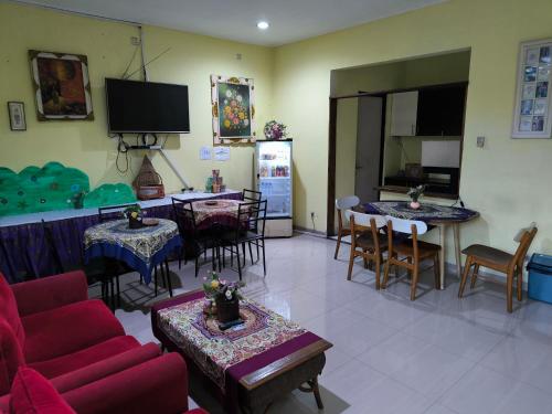 a living room with a couch and tables and a tv at PROMOSIA GUEST HOUSE in Surabaya