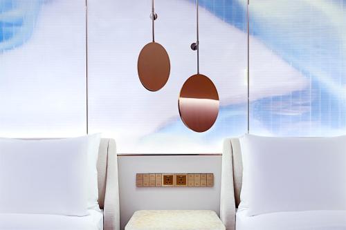 a room with two beds and a chair and pendants at W Chengdu in Chengdu