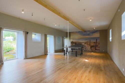 une pièce vide avec une table de ping-pong et un tableau dans l'établissement Gite 8 personnes, à Bégard