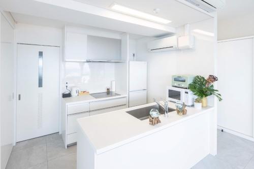 a white kitchen with white cabinets and a sink at MARSOL C,S,Beach hotel - Vacation STAY 50047v in Chigasaki