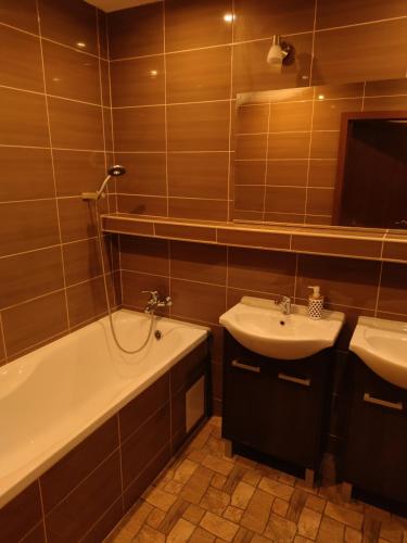 a bathroom with a tub and a sink and a bath tub at Apartment in the Levice in Levice