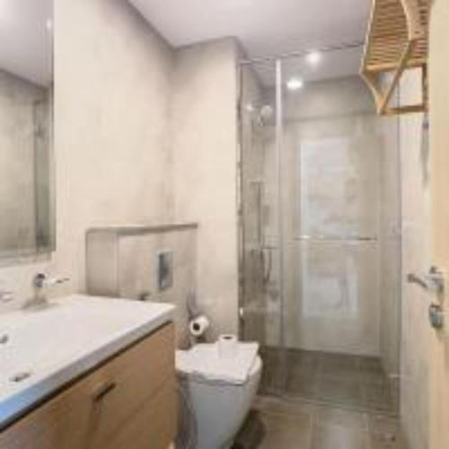 een badkamer met een wastafel, een toilet en een douche bij Key View - Navitas Tower A in ‘Ūd al Bayḑāʼ