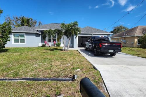 a black truck parked in front of a house at Canal Park Paradise in Port Saint Lucie