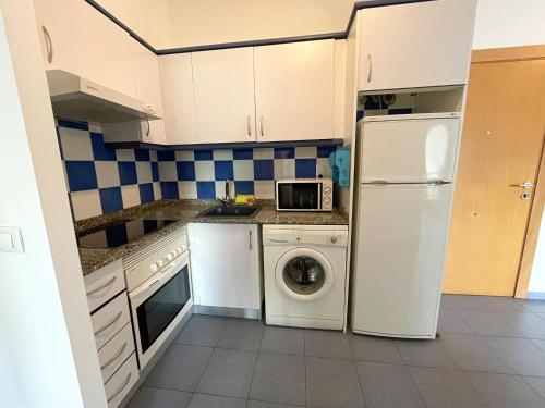 cocina con nevera y lavadora en Apartamentos Mar de Oropesa 3000 en Oropesa del Mar