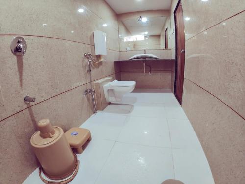 a small bathroom with a toilet and a sink at Hotel Nawanagar Residency in Jamnagar