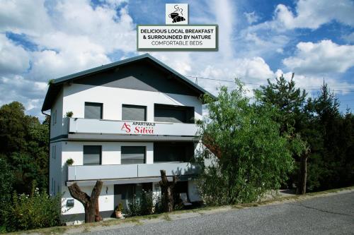 a white building with a sign on top of it at Apartments Silva in Ljutomer