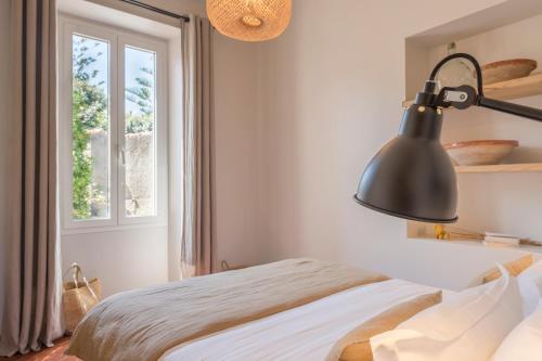 a bedroom with a bed with a black lamp at Boutique hôtel Château Rouher in Propriano