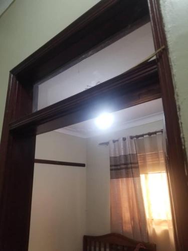 une fenêtre avec une lumière au-dessus d'une porte dans l'établissement Kakande's Pilgrims house, à Kampala