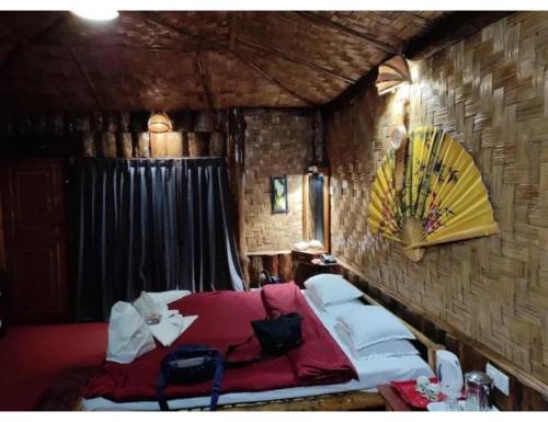 um quarto com uma cama vermelha e uma parede de tijolos em Hilltop Rabong Resort, Sikkim em Ravangla