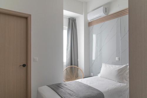 a bedroom with a white bed and a window at Celia Residence in Athens