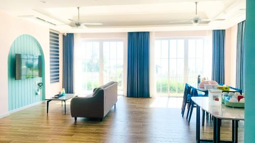 een woonkamer met een tafel en een eetkamer bij Kat House Novaworld Phan Thiết in Bình Tú