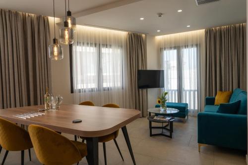 ein Wohnzimmer mit einem Tisch und einem blauen Sofa in der Unterkunft Hestia - Kolokotroni 23 in Athen