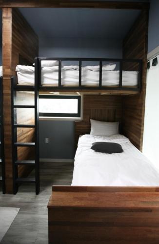 1 dormitorio con 2 literas y escalera en 91 Stay, en Chuncheon