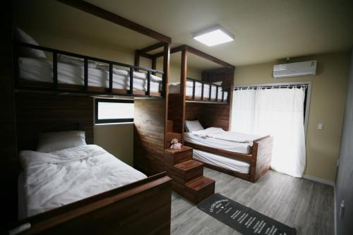 春川的住宿－91 Stay，一间卧室设有两张双层床和一扇窗户。