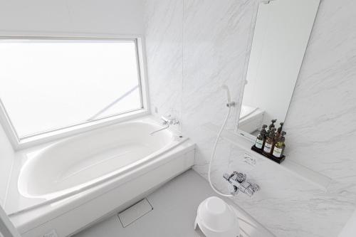 a white bathroom with a tub and a window at MARSOL C,S,Beach hotel - Vacation STAY 50798v in Chigasaki