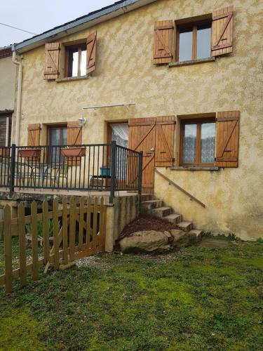 a house with wooden doors and stairs in front of it at Maison dans un village calme in Carla-de-Roquefort